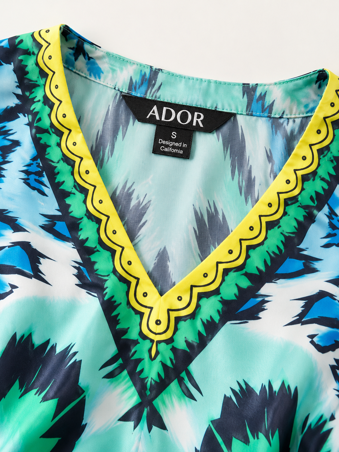 ADOR brand label detail on Land of Wonder Silky Satin Vacation Satin Batwing Top