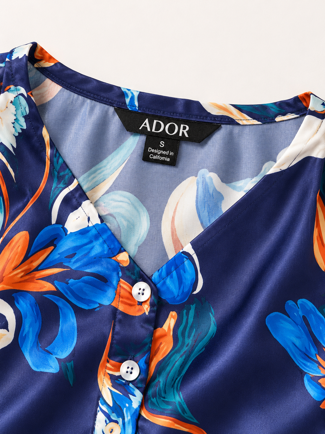 ADOR brand label detail on Blue Watercolor Iris Satin Batwing Top
