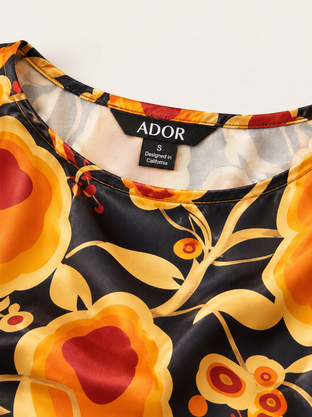 ADOR brand label detail on Sun Ember Silky Satin batwing Top