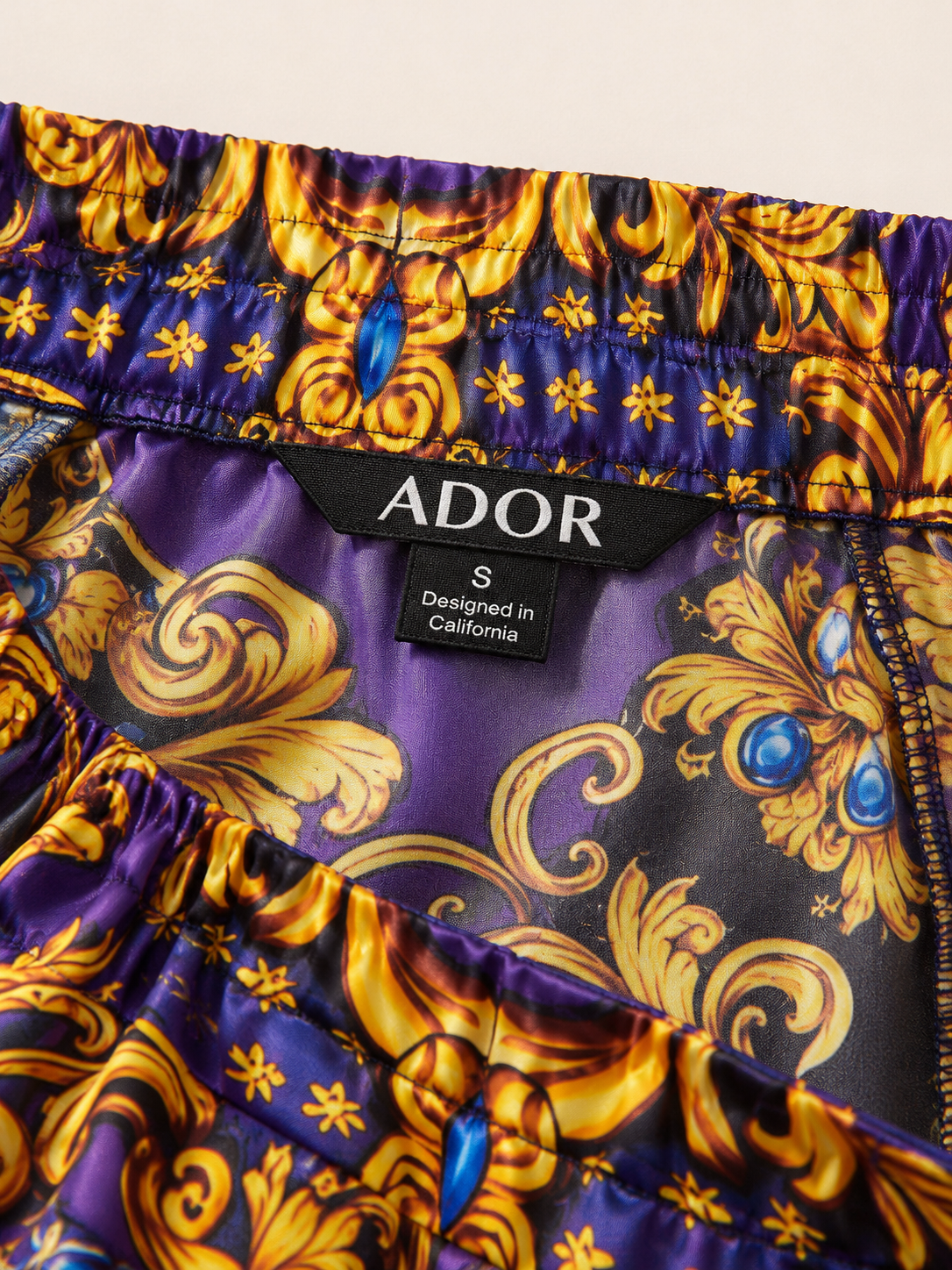 ADOR brand label detail on Midnight Purple Baroque Satin Elastic Waist Straight Pants