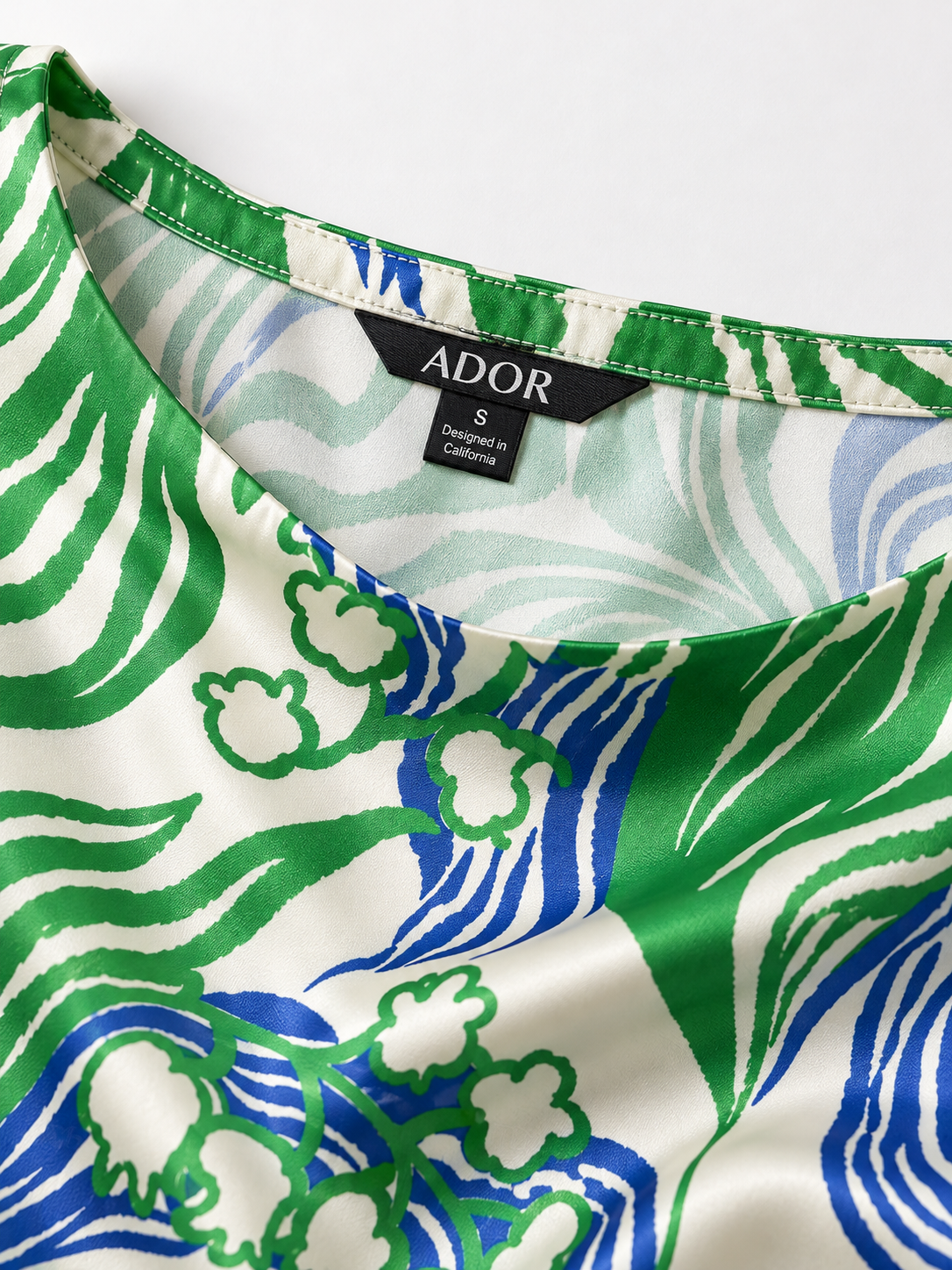 ADOR brand label detail on Abstract Bell Flower Silky Satin Batwing Top