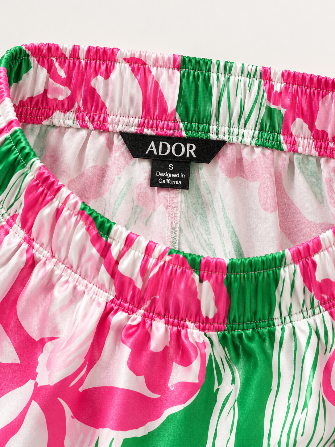 ADOR brand label detail on Pink Jungle Flora Silky Satin Wide Leg Pants