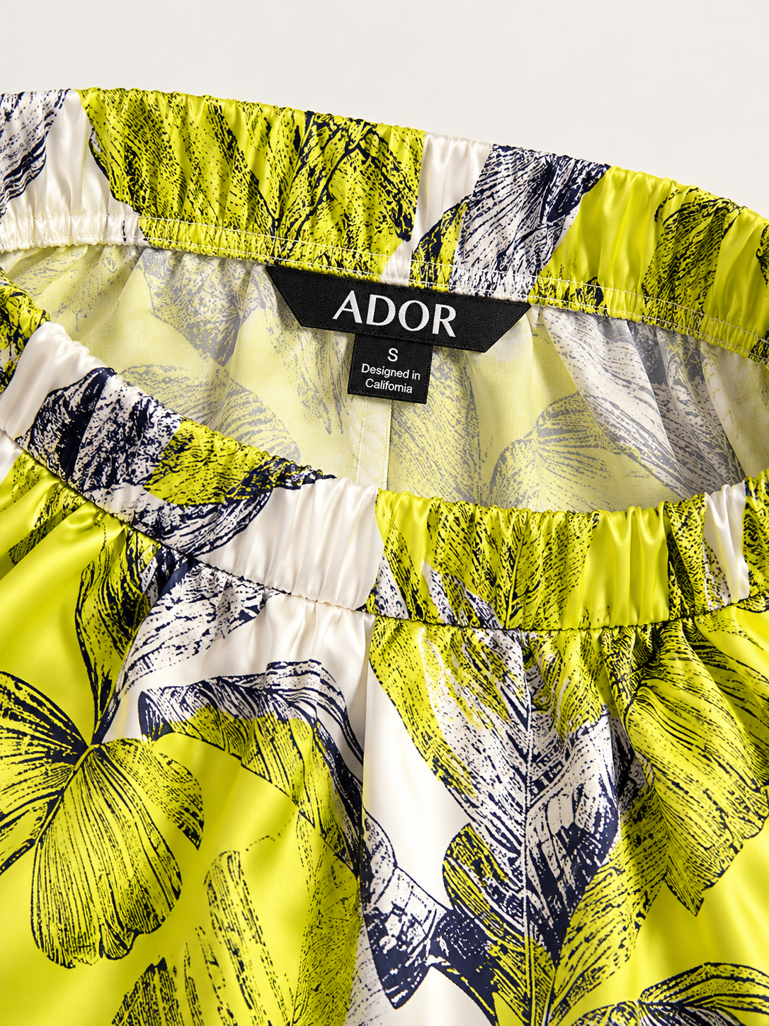 ADOR brand label detail on Citrus Palm Luxe Silky Satin Wide Leg Pants