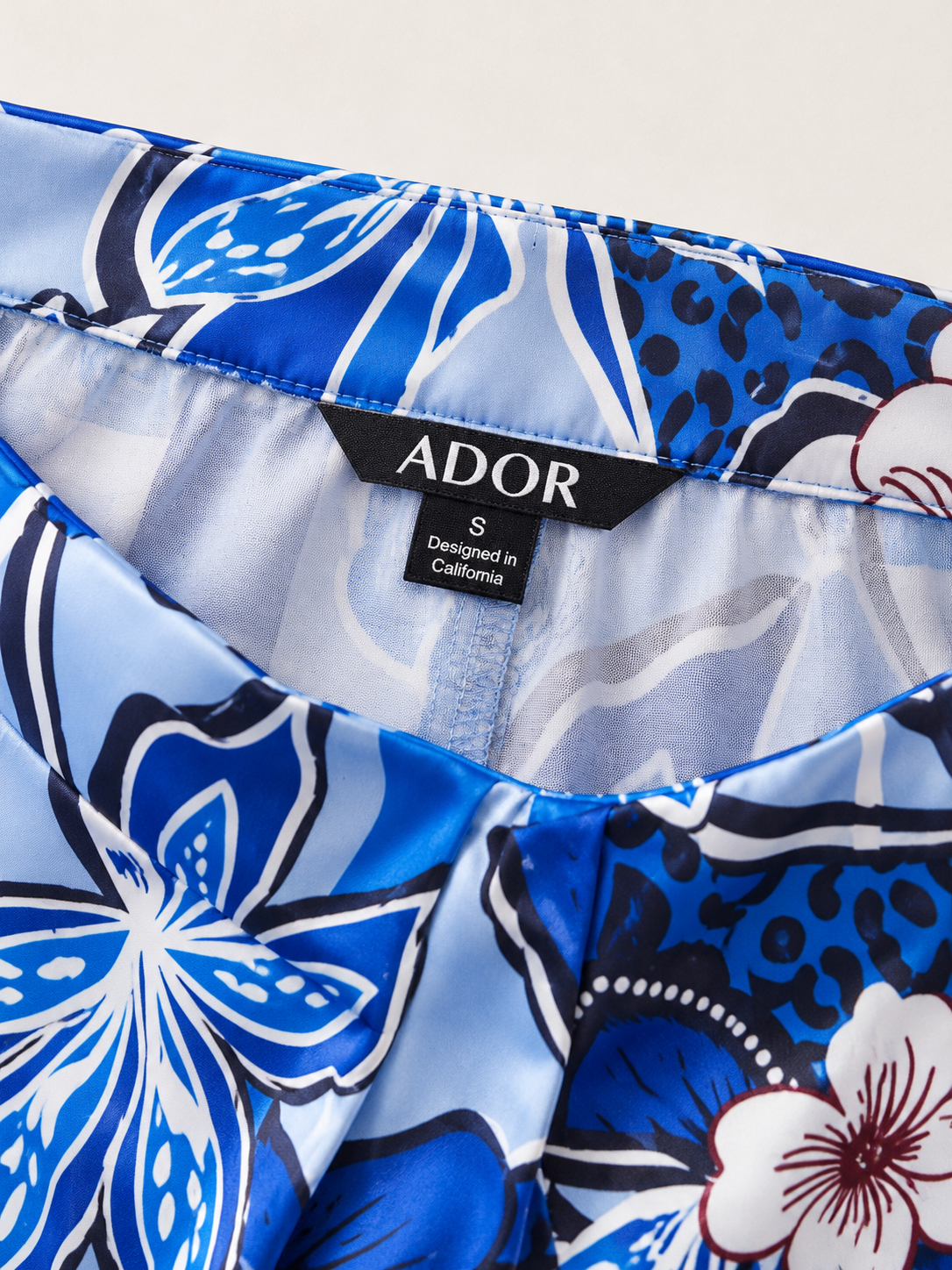ADOR brand label detail on Azure Bloom Satin Slit Wide Leg Pants