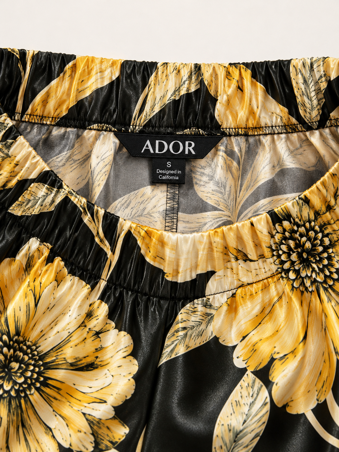 ADOR brand label detail on Cream Yellow Petal Silky Satin Wide Leg Pants