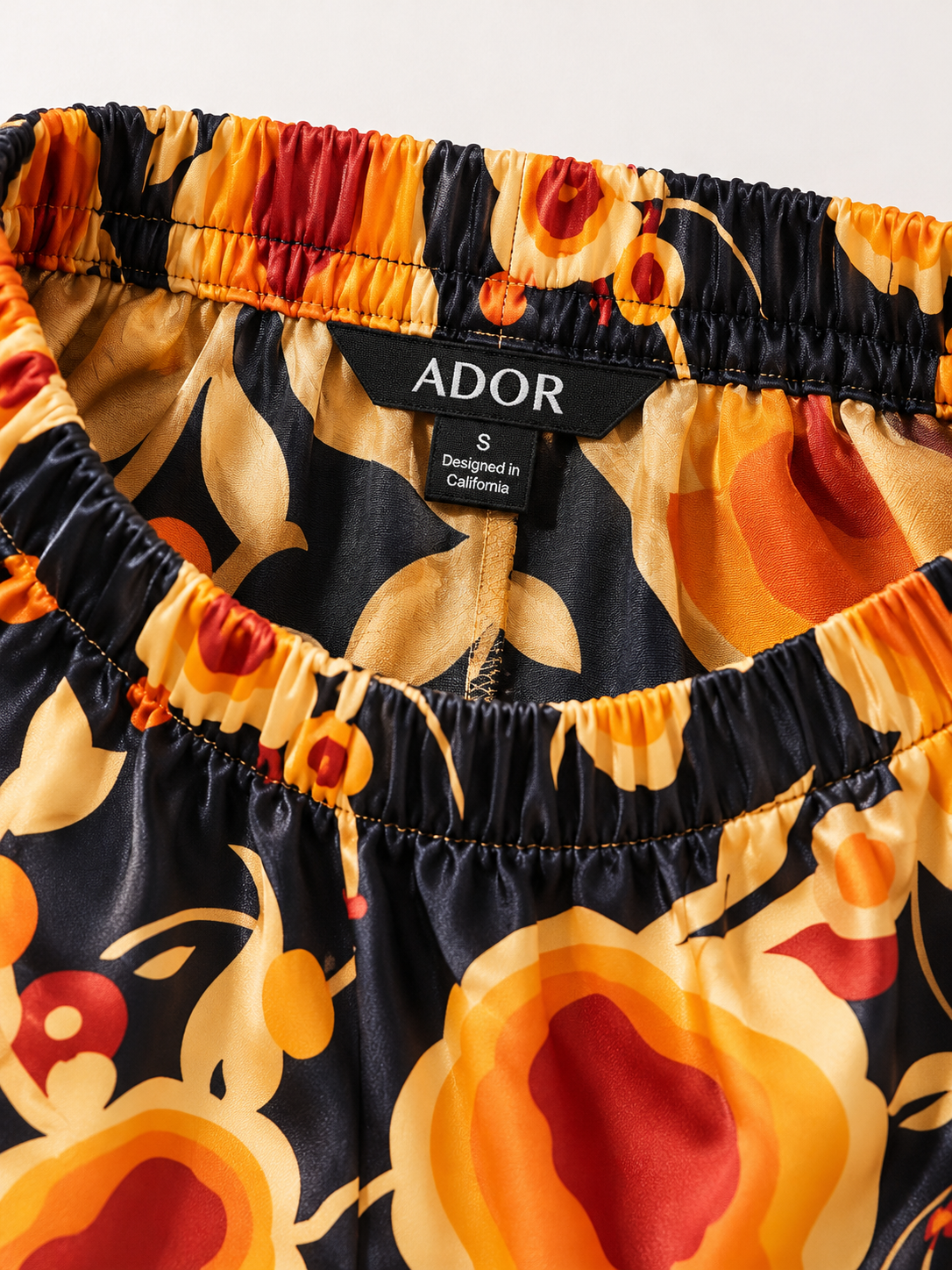 ADOR brand label detail on Sun Ember Silky Satin Wide Leg Pants