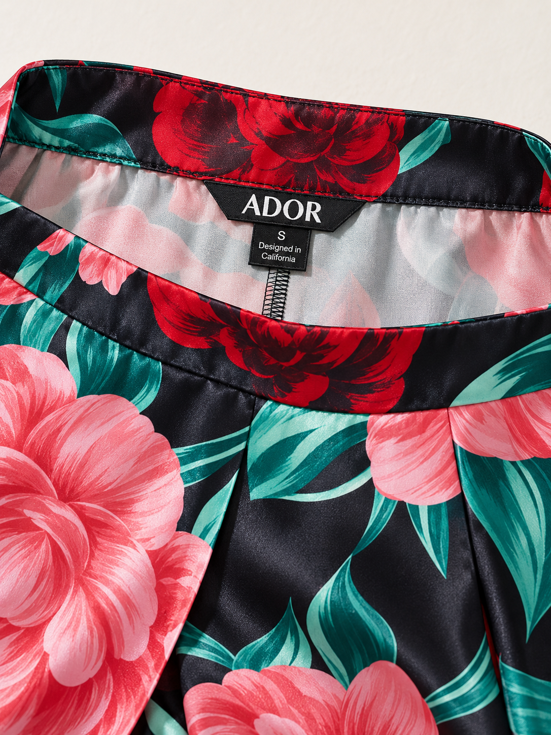 ADOR brand label detail on Emerald Rose Garden Silky Satin Slit Wide Leg Pants