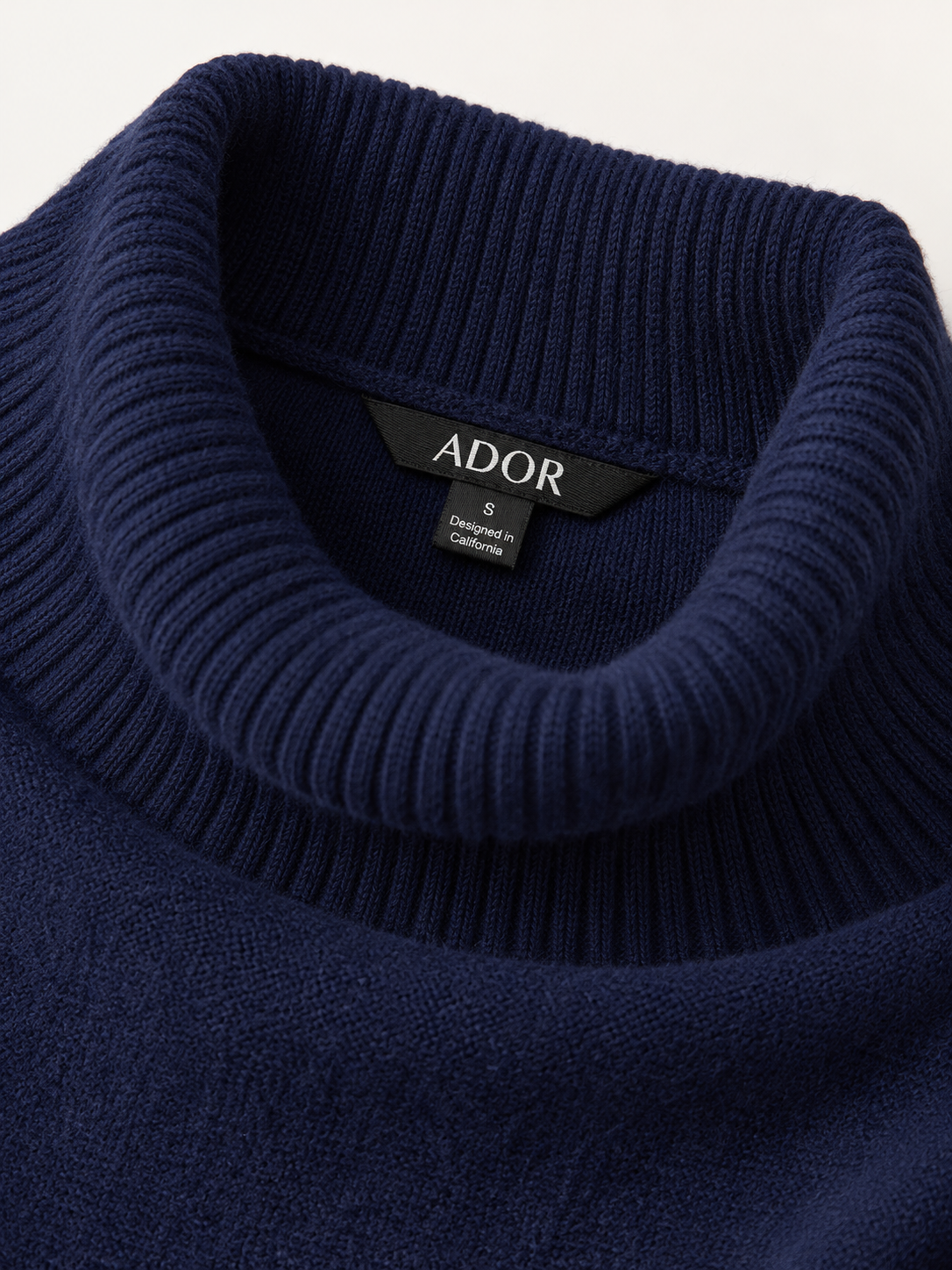 ADOR brand label detail on Arctic Fleece One Piece Sleeve Turtleneck Sweater