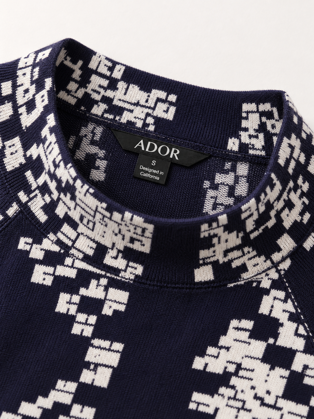 ADOR brand label detail on Tetris Graphic Pullover Sweater