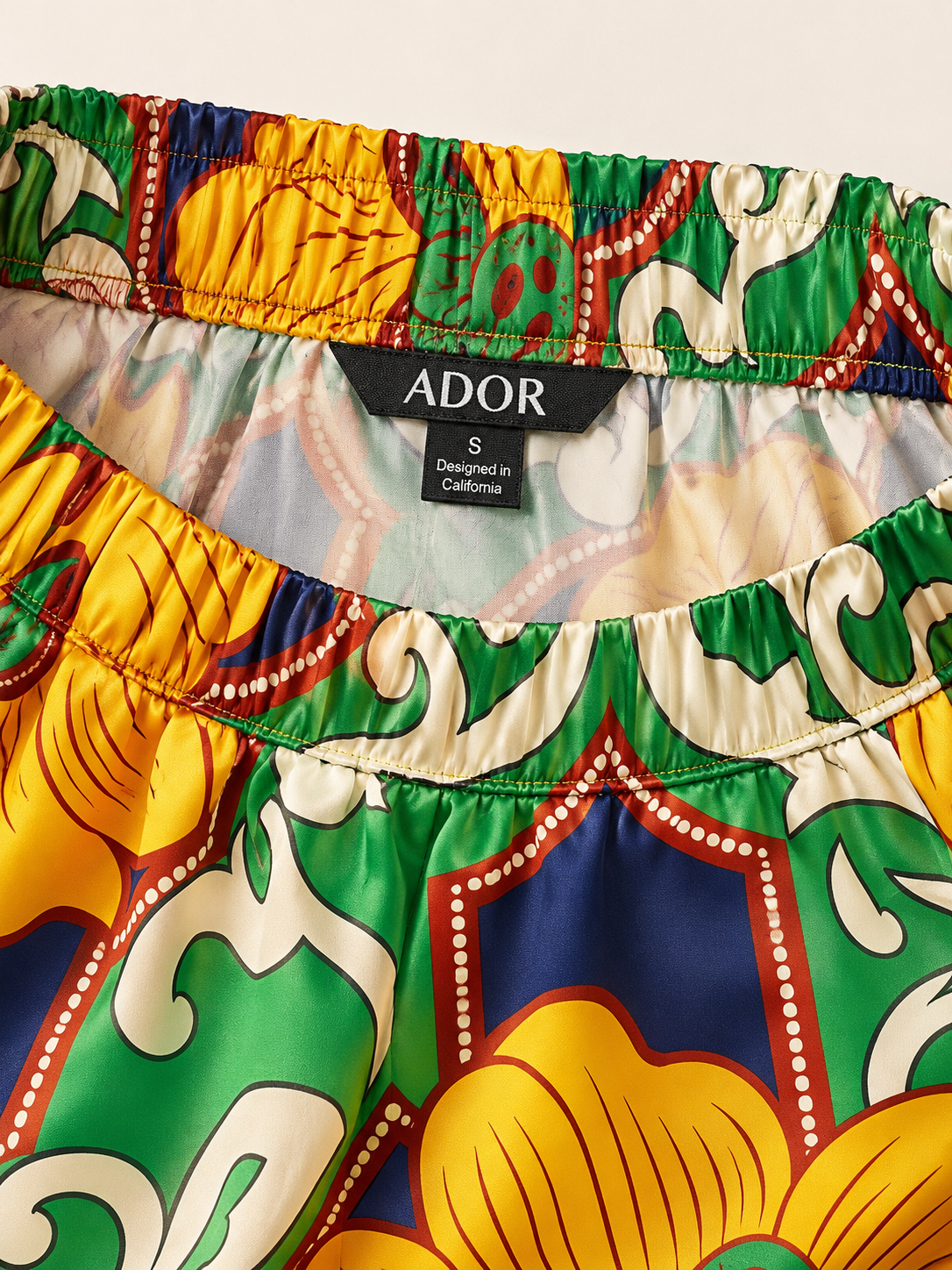 ADOR brand label detail on Emerald Bloom Bazaar Silky Satin Wide Leg Pants